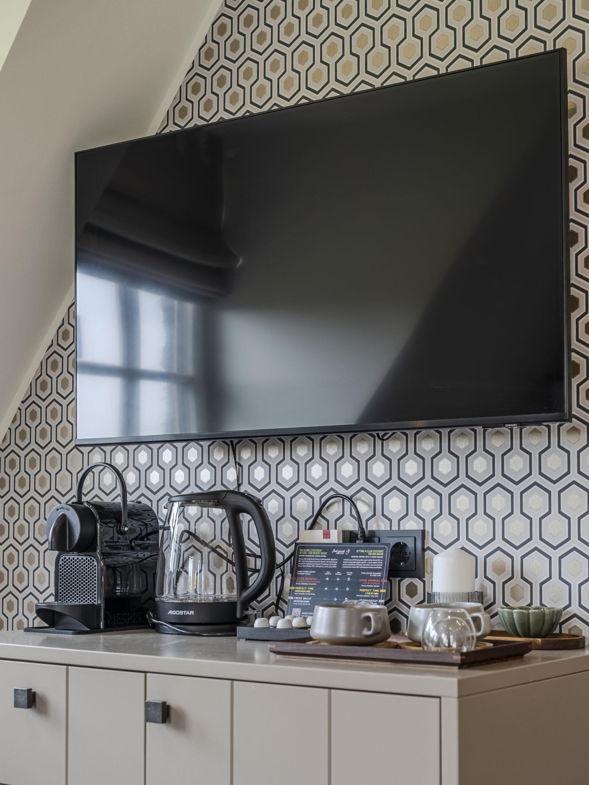 Küchenzeile mit Kaffeemaschine und TV - Hotel Duene Residence 27