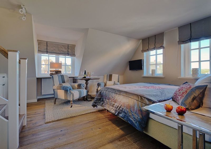 modernes hotelzimmer in maritimem stil mit sesseln, bett und deko hotel appartment sylt