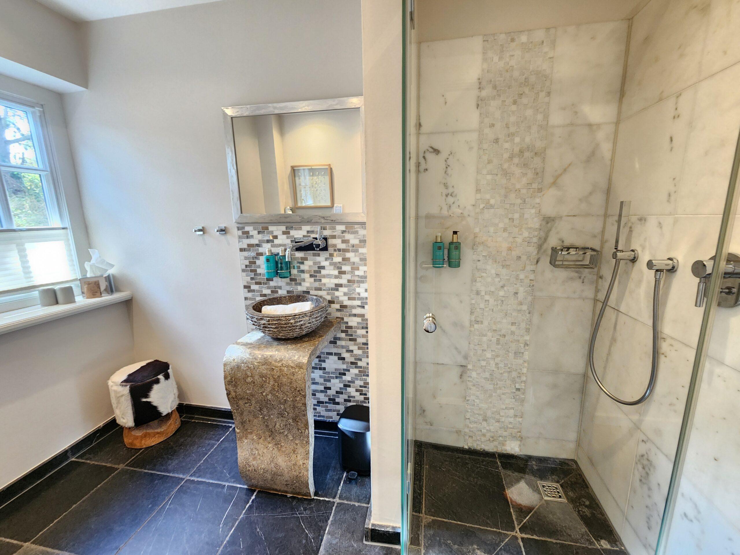 Badezimmer der Suite 8 im Hotel Duene Sylt mit großer Dusche