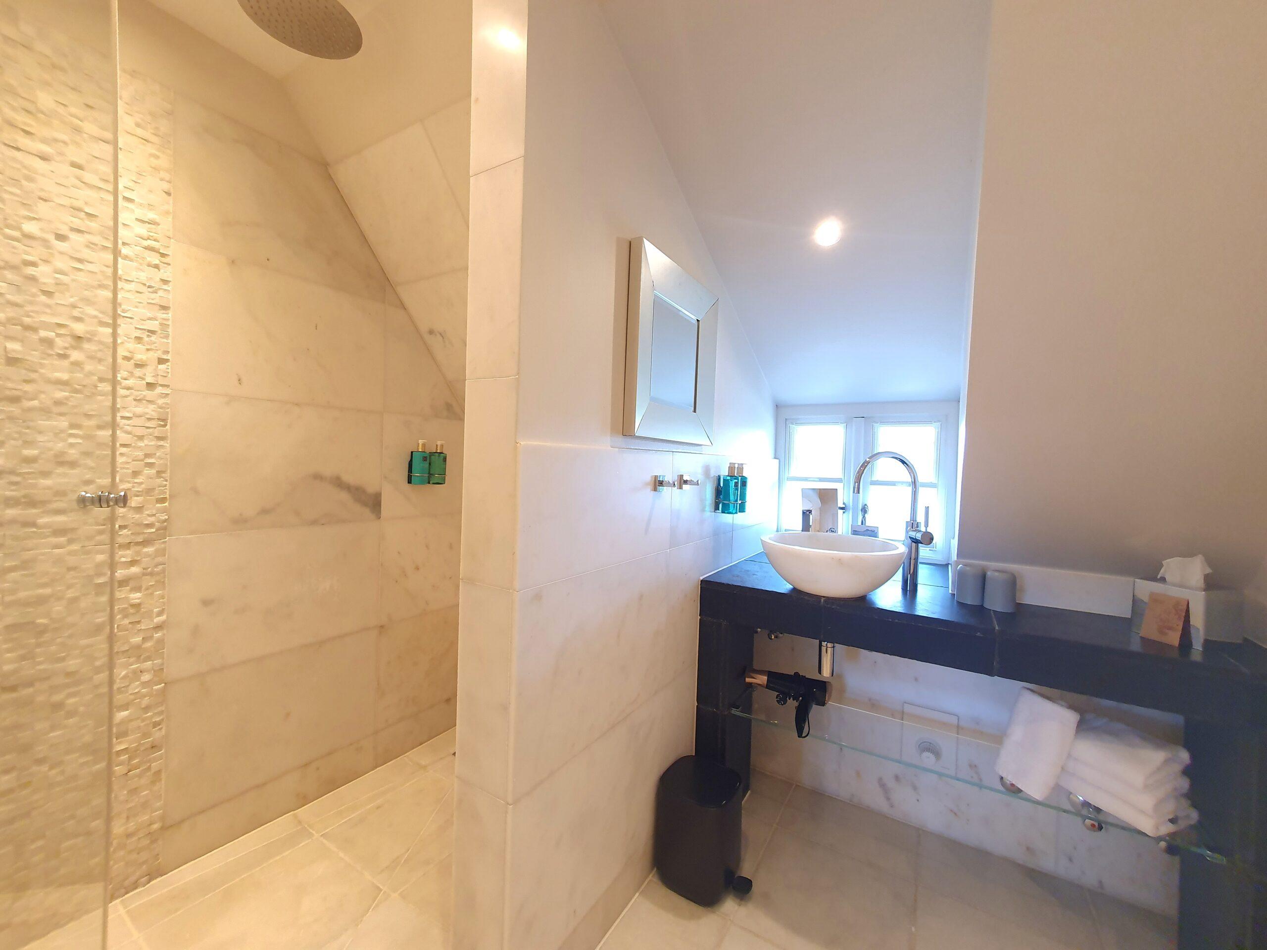 waschtisch und dusche im badezimmer des duene zimmer 15 im hotel in rantum
